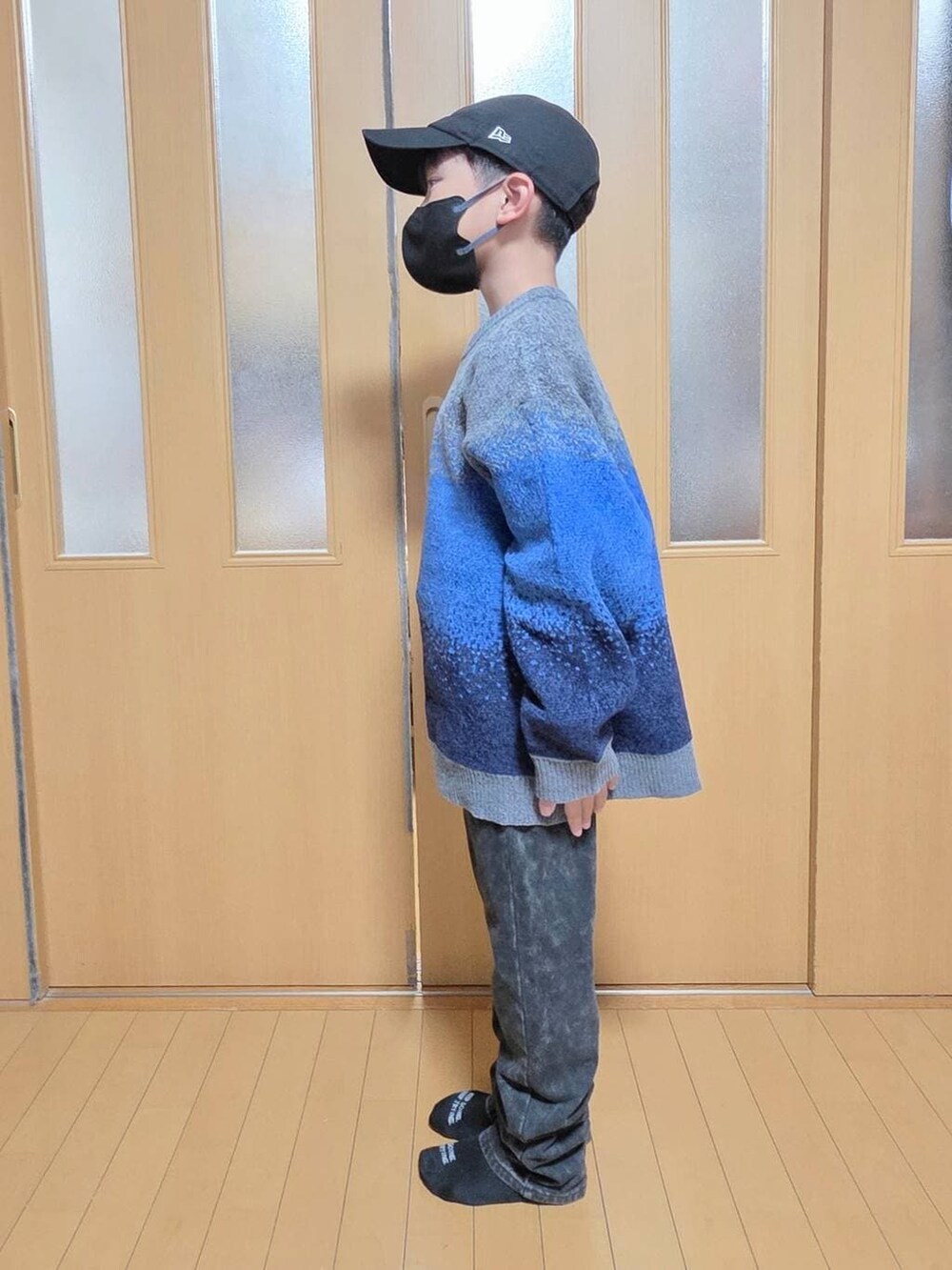 ブラック系のブルゾン、ブラック系のデニムパンツ、グレー系のニット/セーターを着用したキッズの冬コーディネートの2枚目の写真