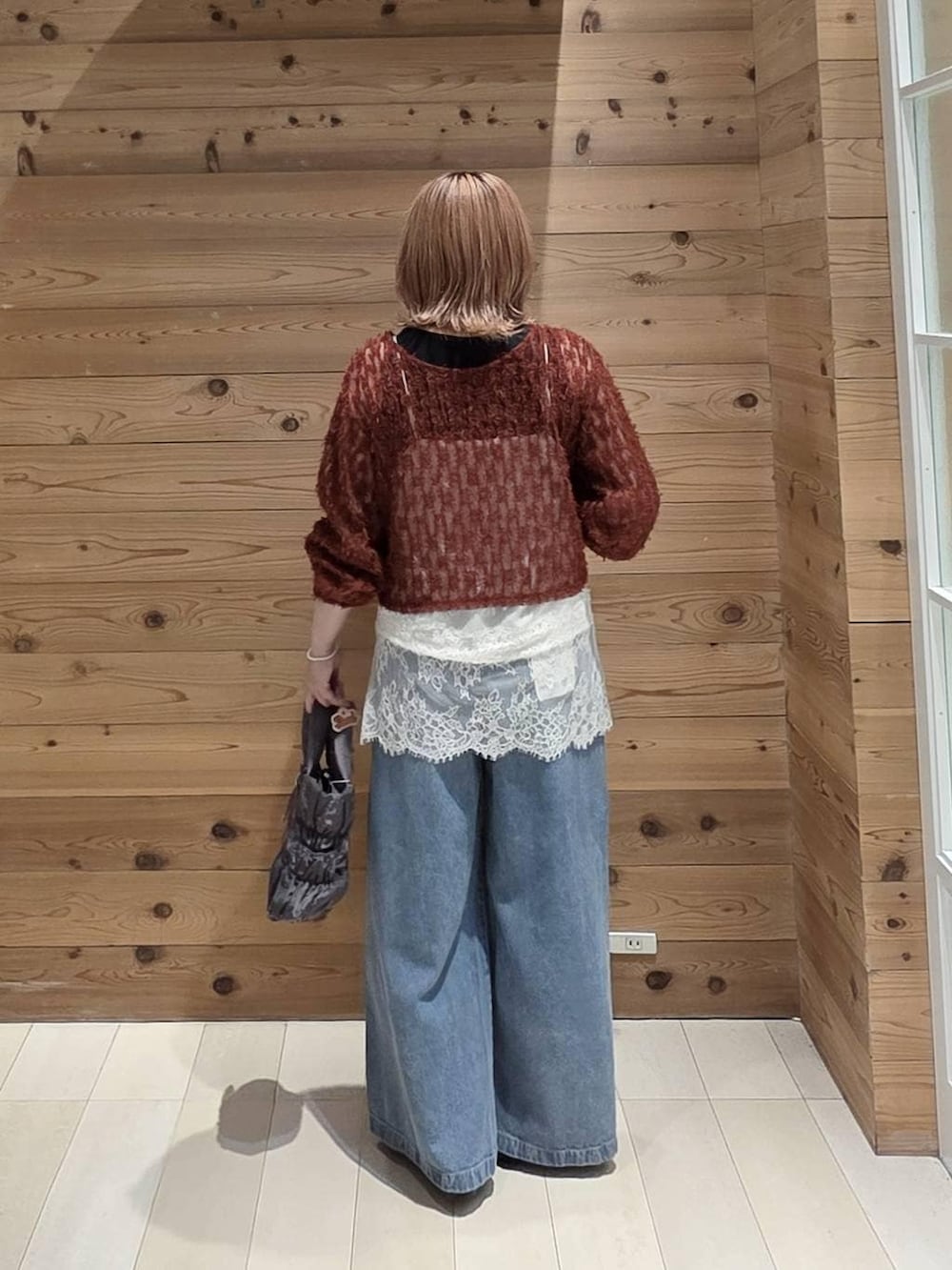 レッド系のカーディガン/ボレロ、ブラック系のバレエシューズ、グレー系のトートバッグを着用したレディースの秋コーディネートの3枚目の写真