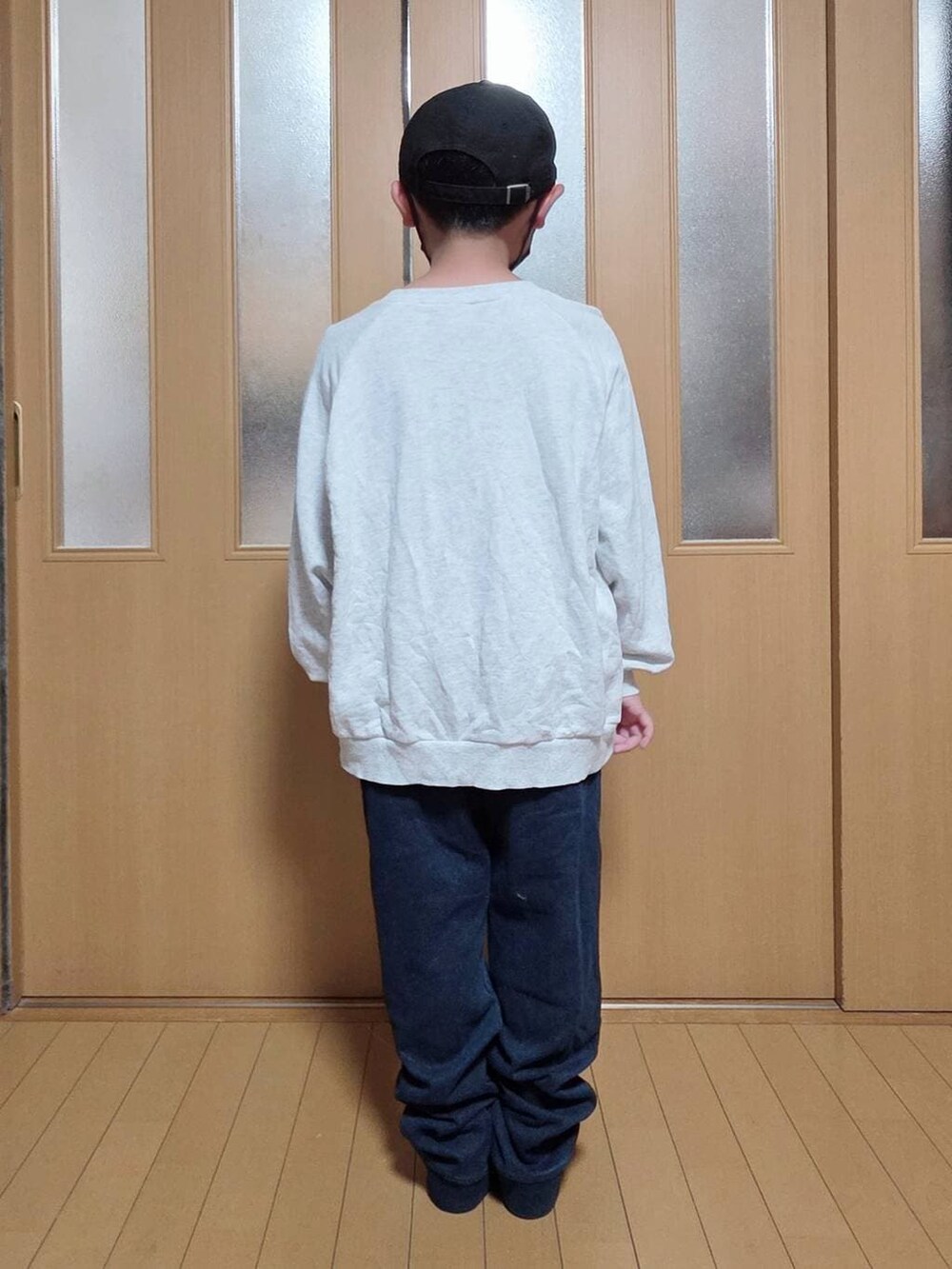 ベージュ系のブルゾン、ブルー系のデニムパンツ、グレー系のスウェットを着用したキッズの秋コーディネートの6枚目の写真