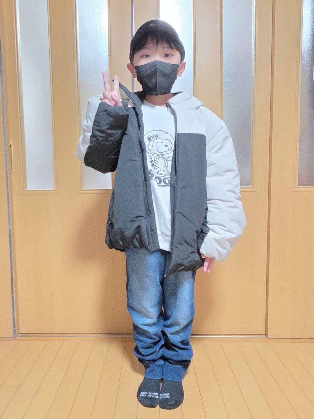 ベージュ系のブルゾン、ブルー系のデニムパンツ、グレー系のスウェットを着用したキッズの秋コーディネートの2枚目の写真