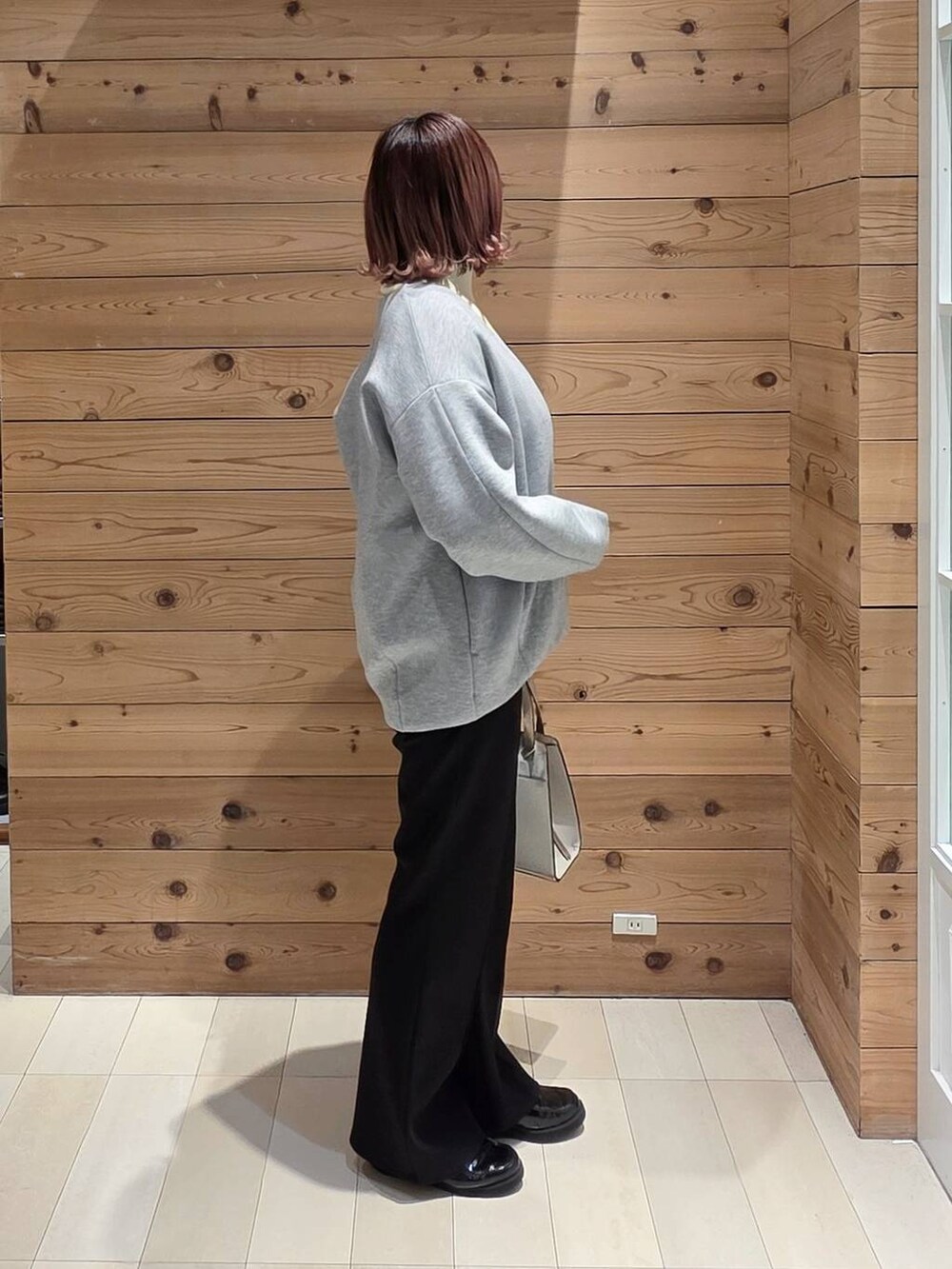 ブラック系のローファー、ホワイト系のショルダーバッグ、ホワイト系のTシャツ/カットソーを着用したレディースの冬コーディネートの2枚目の写真