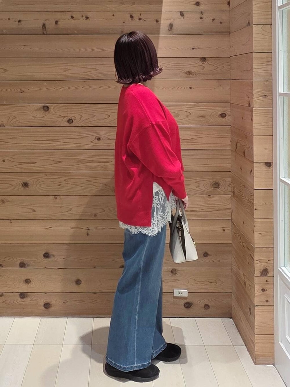 ホワイト系のショルダーバッグ、ブラック系のダウンジャケット/コート、ブラック系のブーツを着用したレディースの冬コーディネートの2枚目の写真