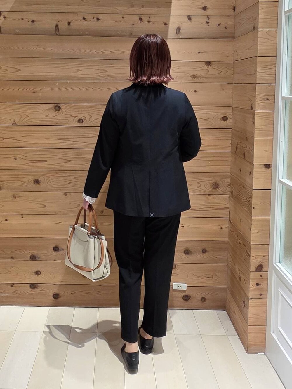 ブラック系のローファー、ホワイト系のシャツ/ブラウス、ブルー系のスラックスを着用したレディースの春コーディネートの3枚目の写真