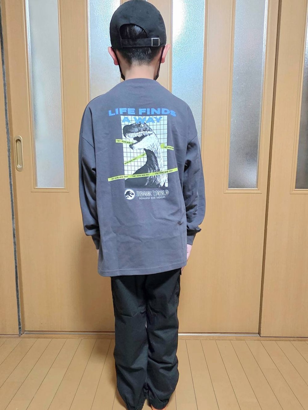 ブラック系のカーゴパンツ、グレー系のTシャツ/カットソー、ブラック系のキャップを着用したキッズの秋コーディネートの3枚目の写真