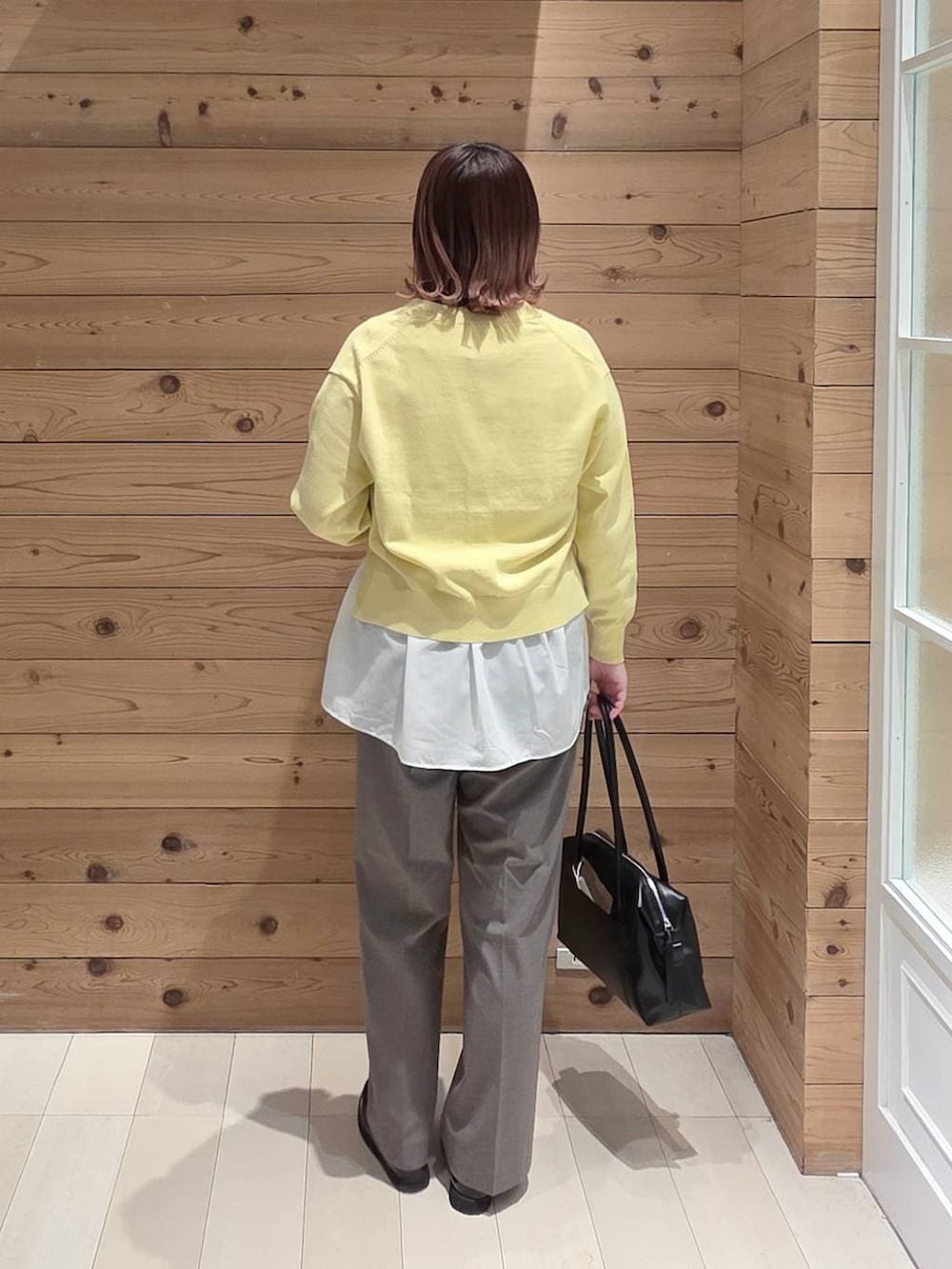 ブラック系のローファー、ブラック系のボストンバッグ、ブラウン系のスラックスを着用したレディースの春コーディネートの3枚目の写真