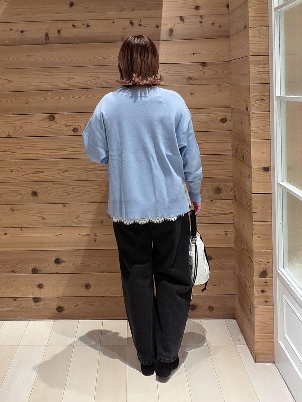 ブルー系のダウンジャケット/コート、ブラック系のデニムパンツ、ホワイト系のハンドバッグを着用したレディースの冬コーディネートの3枚目の写真