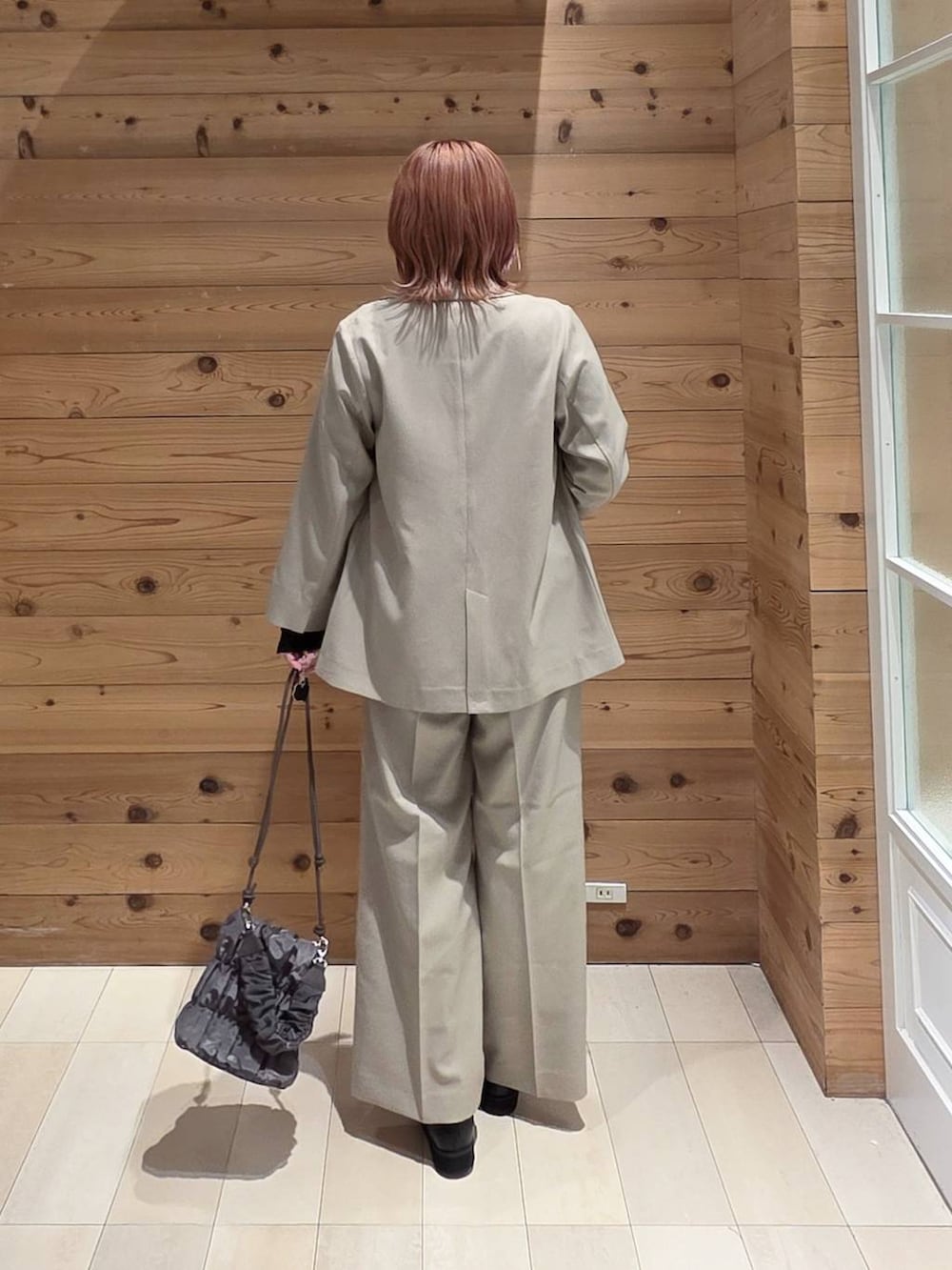 ブラック系のTシャツ/カットソー、ブラック系のローファー、グレー系のショルダーバッグを着用したレディースの秋コーディネートの3枚目の写真