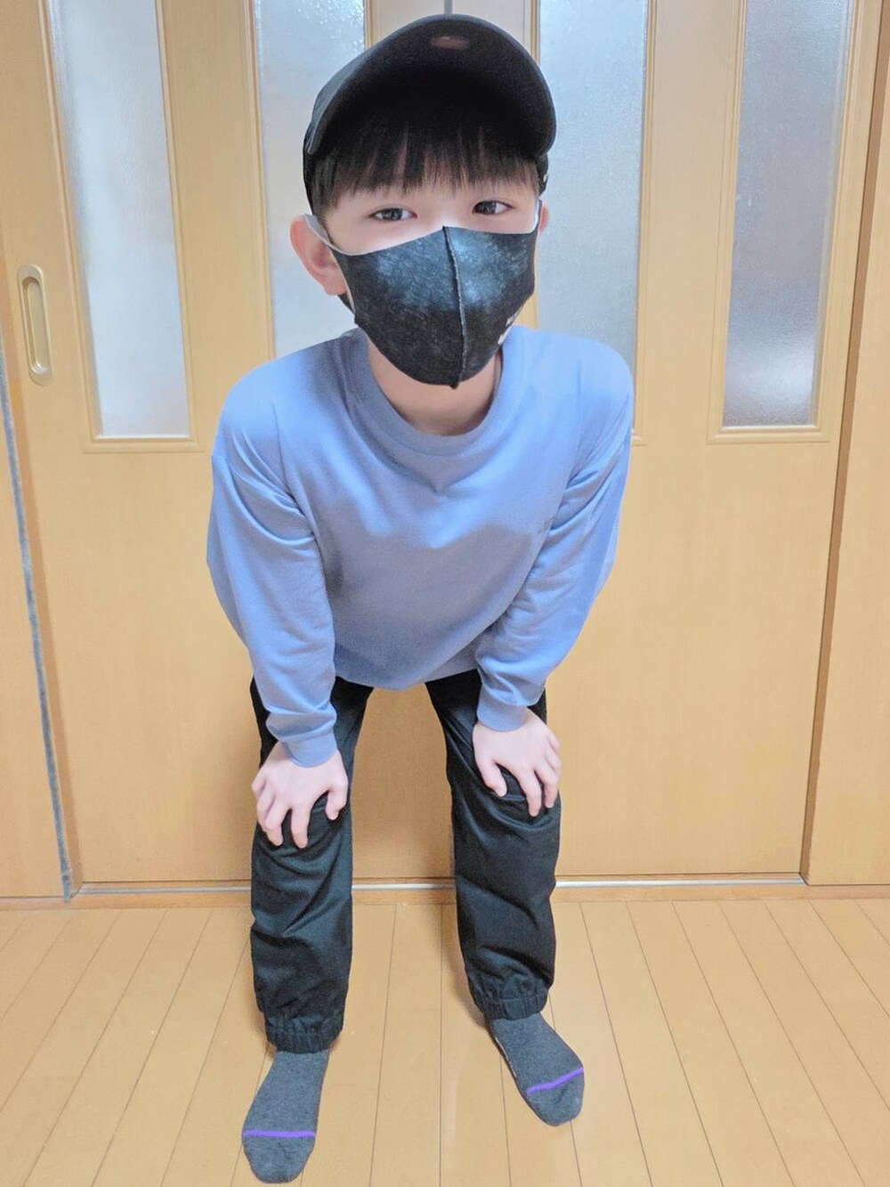 ブラック系のカーゴパンツ、ブルー系のTシャツ/カットソー、ブラック系のキャップを着用したキッズの秋コーディネートの4枚目の写真