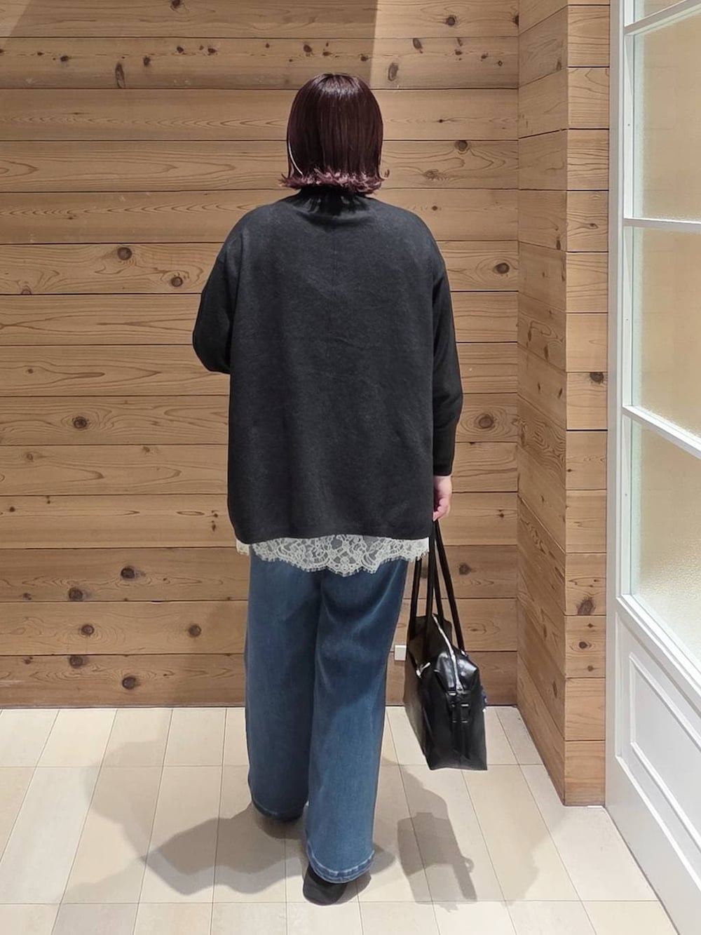 ブラック系のダウンジャケット/コート、ブラック系のボストンバッグ、ブラック系のブーツを着用したレディースの冬コーディネートの3枚目の写真