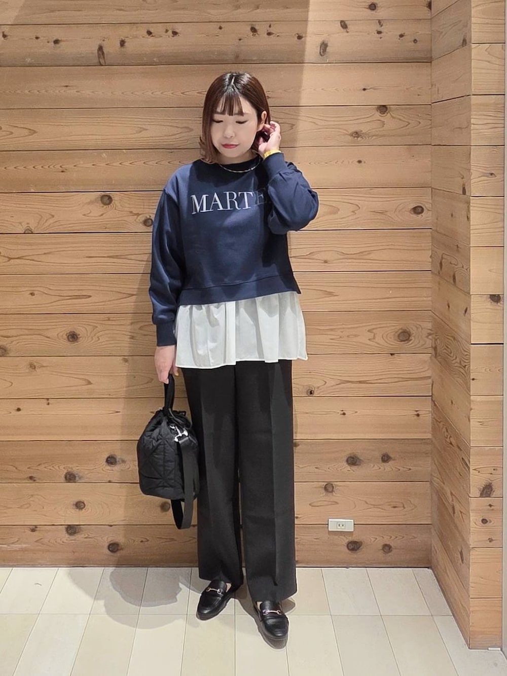 ブラック系のローファー、ブラック系のハンドバッグ、ブルー系のスウェットを着用したレディースの春コーディネートの2枚目の写真