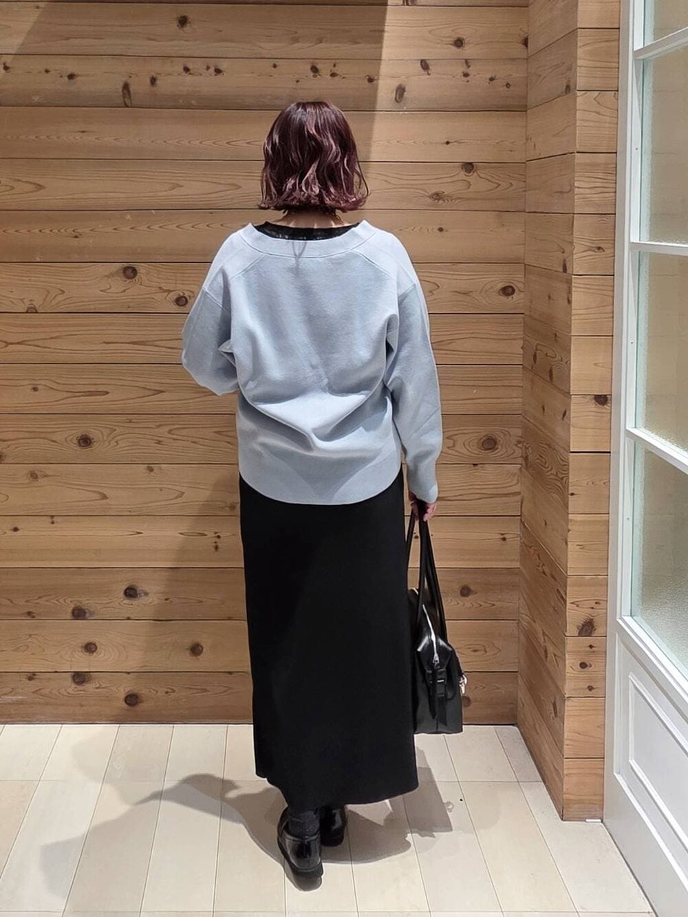 ブラック系のローファー、ブラック系のボストンバッグ、ブラック系のTシャツ/カットソーを着用したレディースの冬コーディネートの3枚目の写真