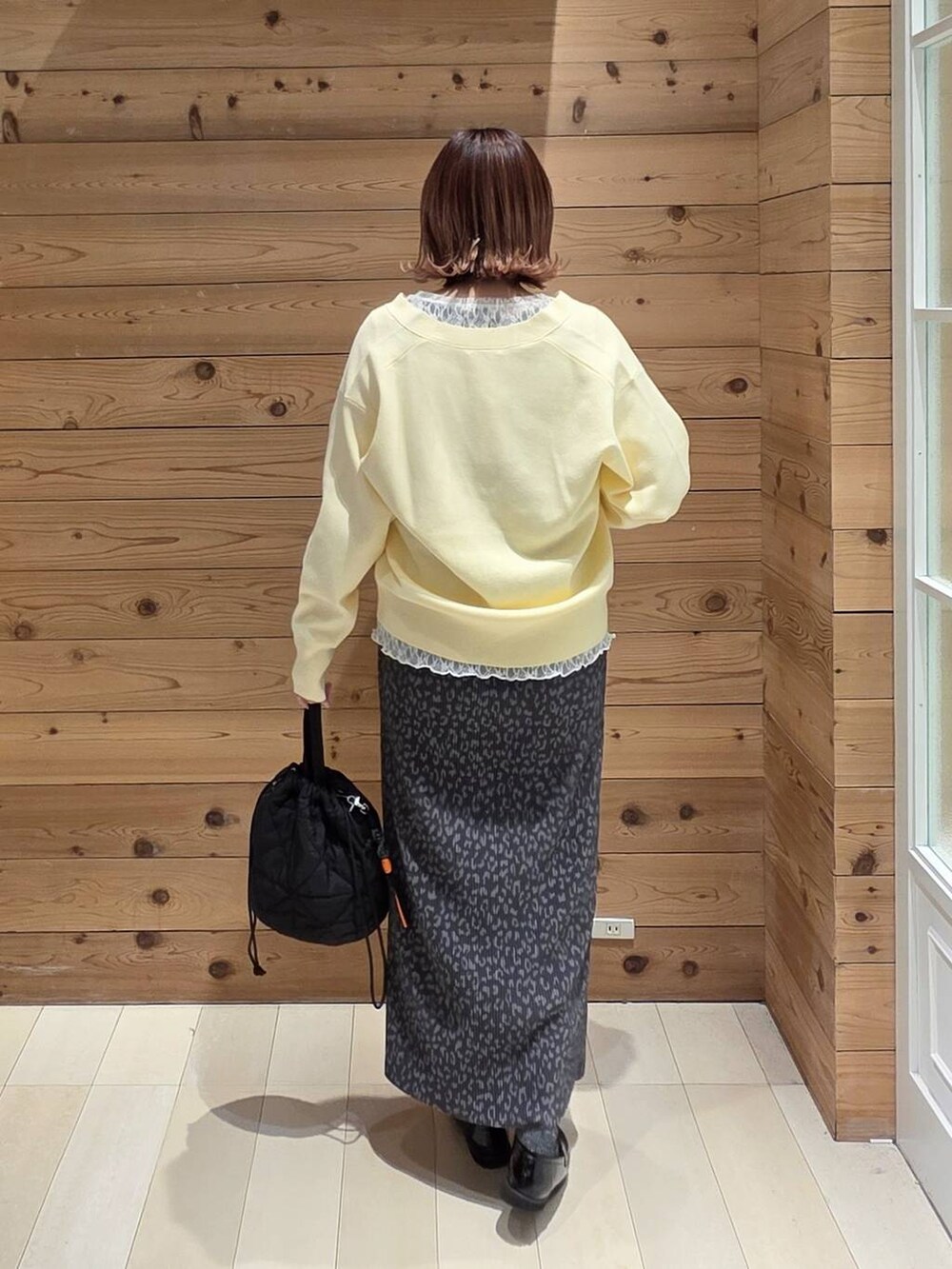 ブラック系のローファー、ブラック系のハンドバッグ、ブラック系のマウンテンパーカーを着用したレディースの春コーディネートの3枚目の写真