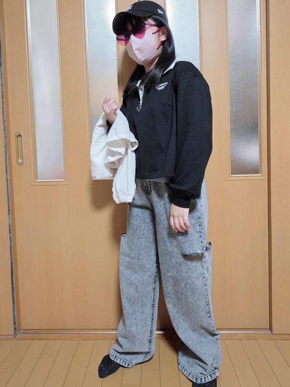 ブラック系のデニムパンツ、ホワイト系のマウンテンパーカー、ブラック系のTシャツ/カットソーを着用したキッズの秋コーディネートの5枚目の写真