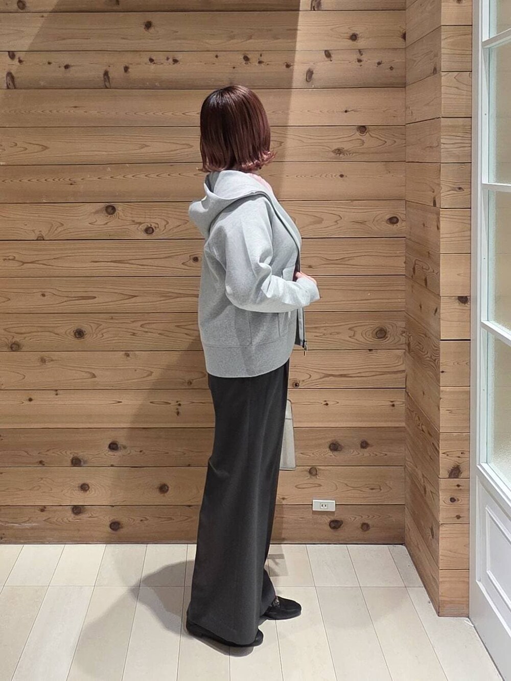 ブラック系のローファー、ホワイト系のショルダーバッグ、グレー系のパーカーを着用したレディースの冬コーディネートの2枚目の写真