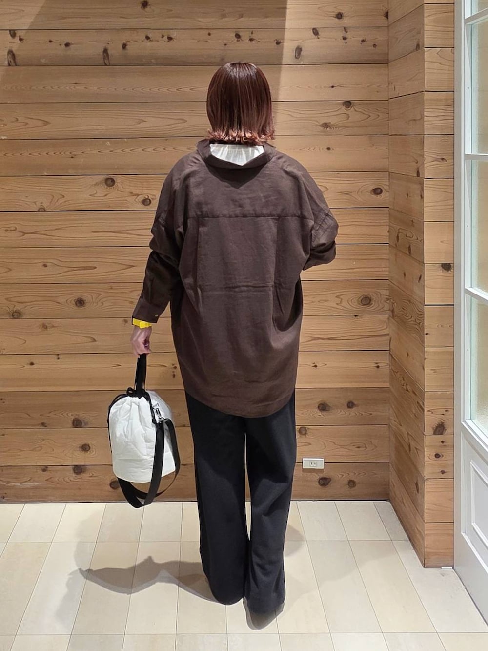 ブラック系のバレエシューズ、ホワイト系のハンドバッグ、ブラウン系のシャツ/ブラウスを着用したレディースの春コーディネートの3枚目の写真