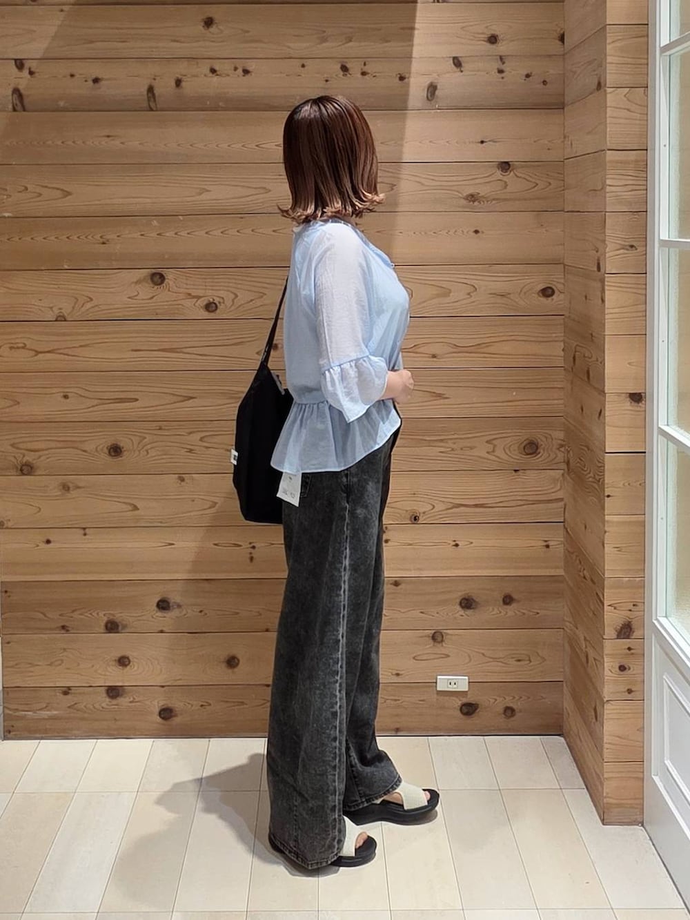 ブラック系のデニムパンツ、ホワイト系のタンクトップ、ホワイト系のサンダルを着用したレディースの夏コーディネートの2枚目の写真