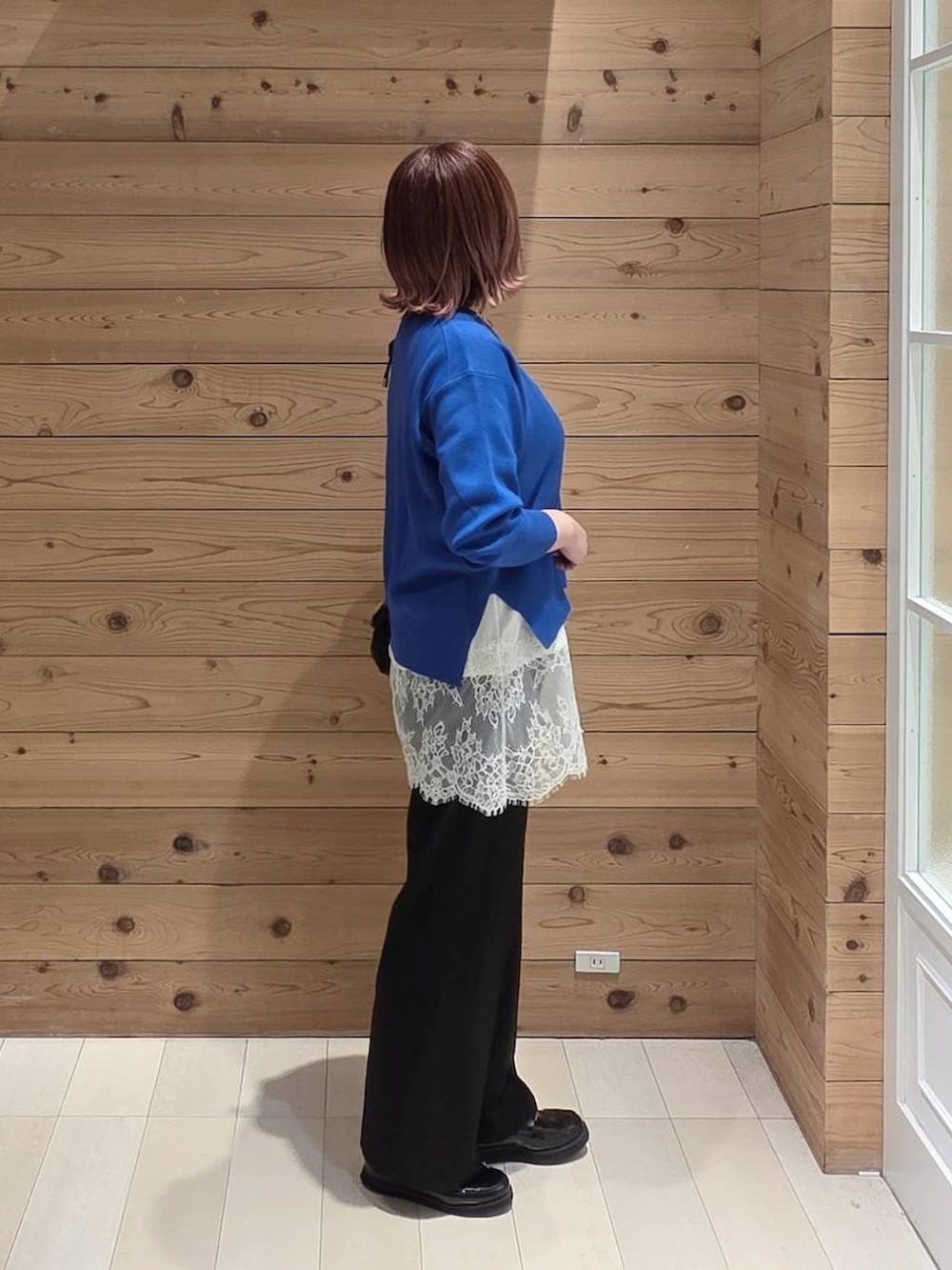 ブラック系のローファー、ブラック系のショルダーバッグ、ブラック系のスラックスを着用したレディースの春コーディネートの2枚目の写真