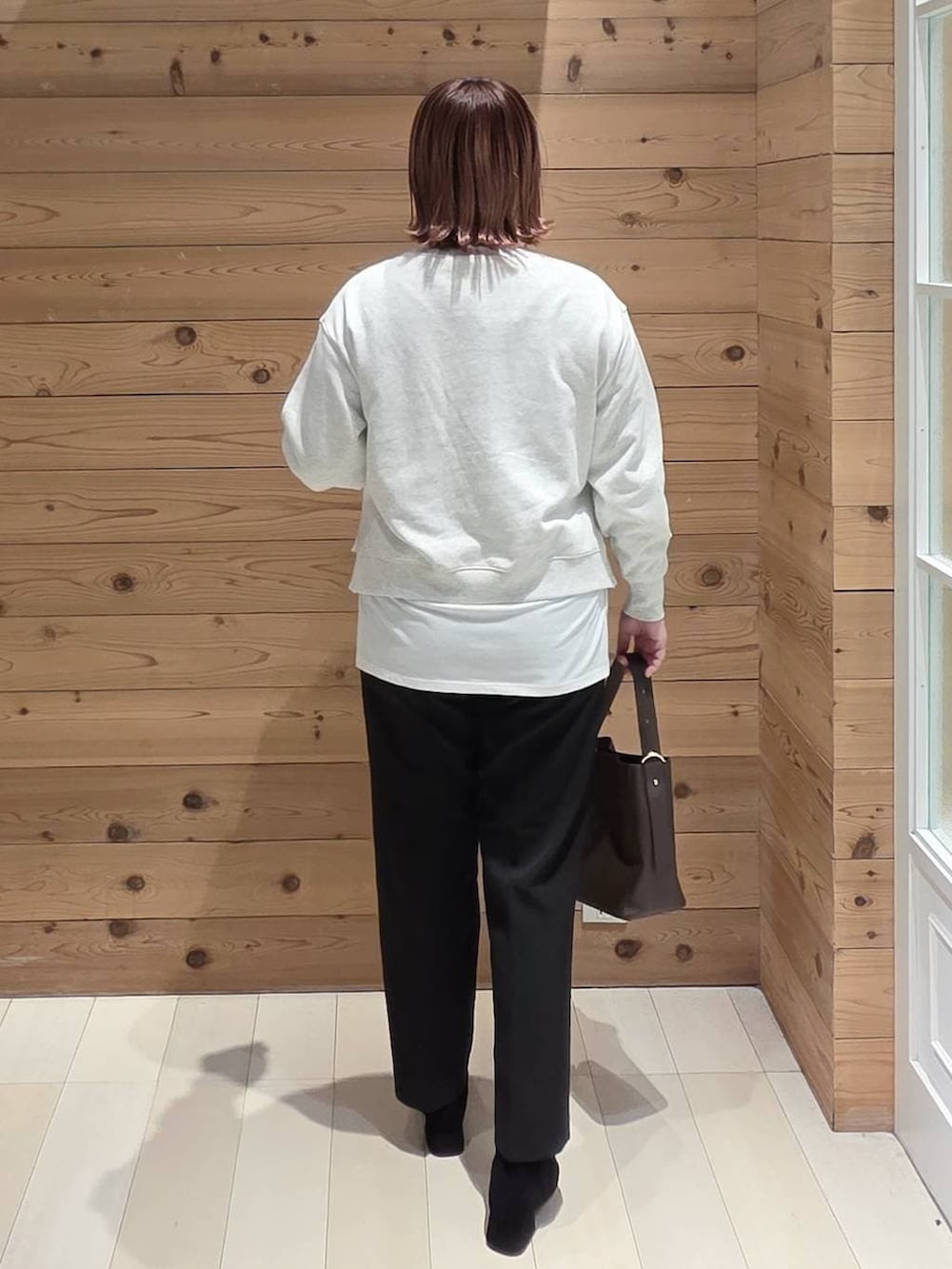 ブラウン系のショルダーバッグ、ベージュ系のチェスターコート、ブラック系のその他パンツを着用したレディースの秋コーディネートの3枚目の写真