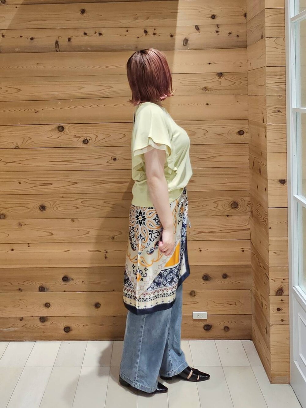 イエロー系のTシャツ/カットソー、ブラック系のパンプス、シルバー系のショルダーバッグを着用したレディースの夏コーディネートの2枚目の写真