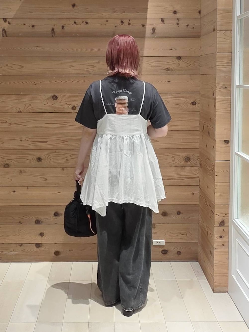 ホワイト系のシャツ/ブラウス、ブラック系のハンドバッグ、ブラック系のデニムパンツを着用したレディースの夏コーディネートの3枚目の写真