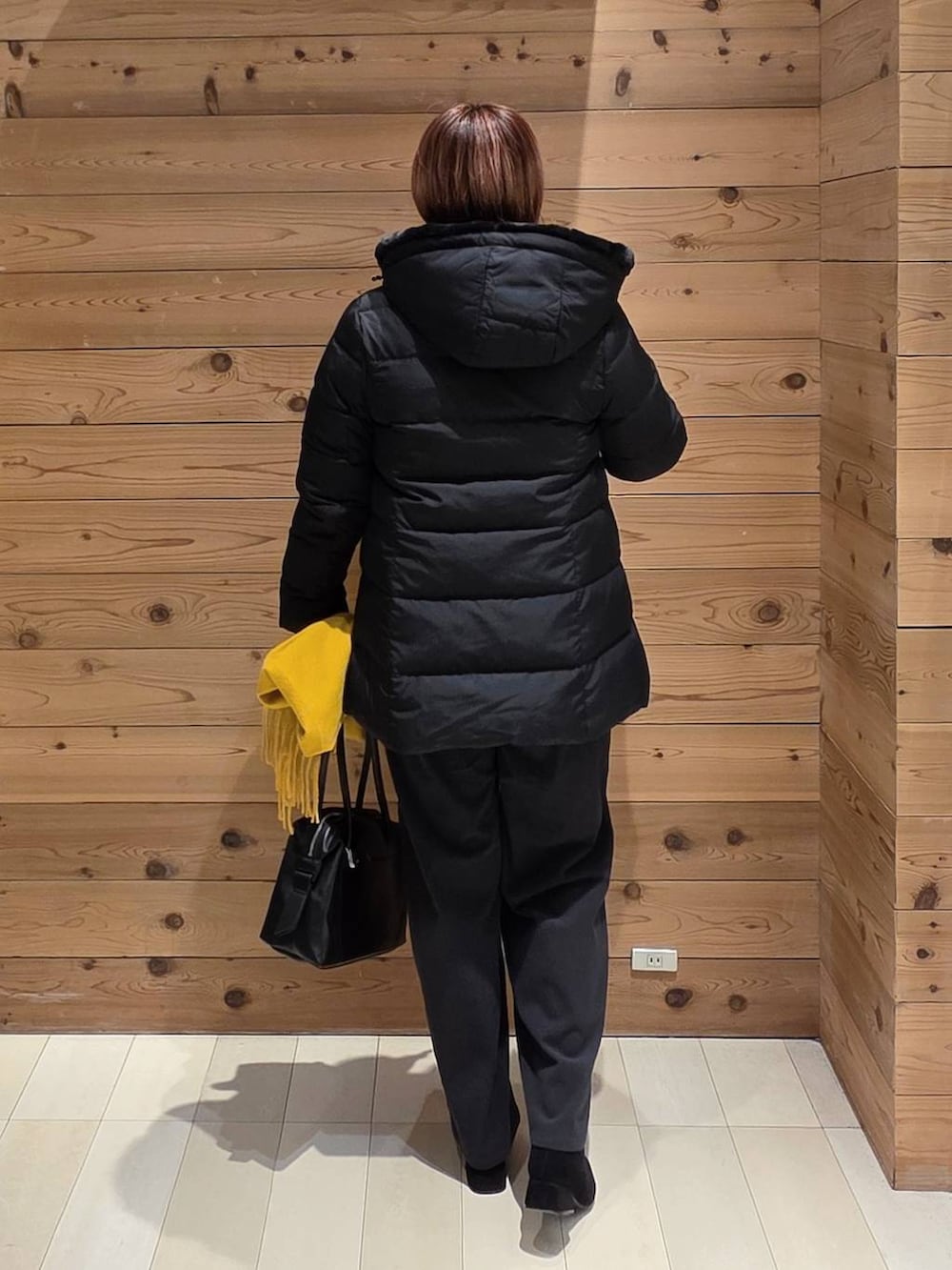 ブラック系のボストンバッグ、ブラック系のダウンジャケット/コート、ホワイト系のシャツ/ブラウスを着用したレディースの冬コーディネートの3枚目の写真