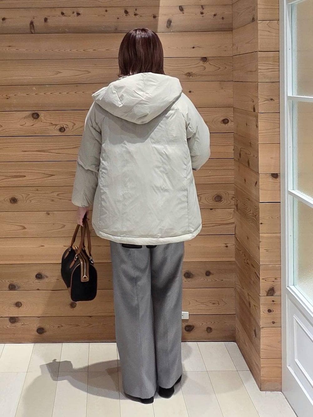 ベージュ系のダウンジャケット/コート、シルバー系のニット/セーター、グレー系のその他パンツを着用したレディースの冬コーディネートの3枚目の写真