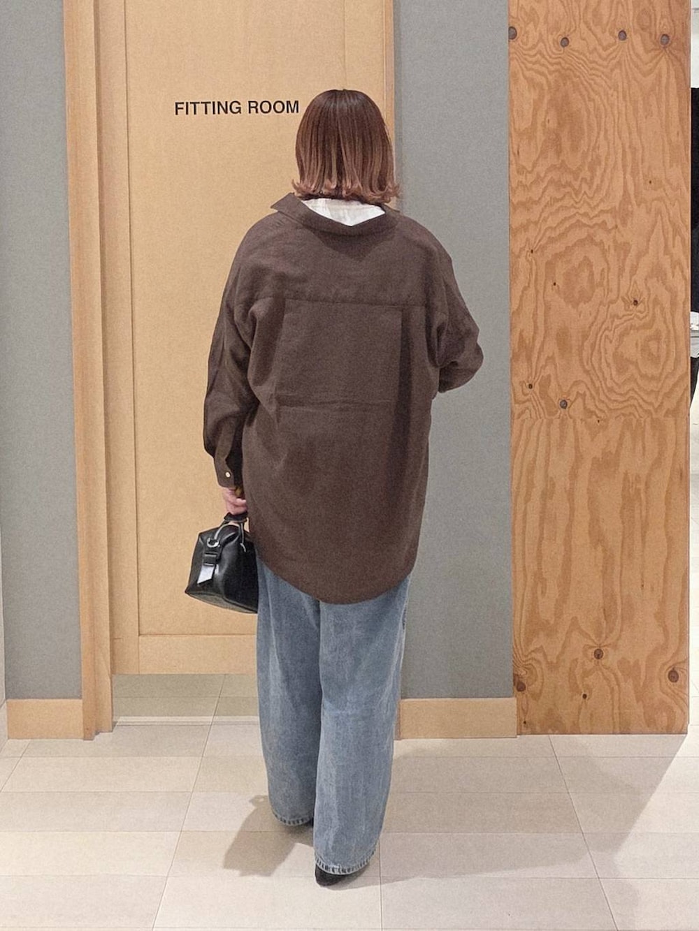 ブラック系のバレエシューズ、ブルー系のデニムパンツ、ブラック系のボストンバッグを着用したレディースの春コーディネートの3枚目の写真