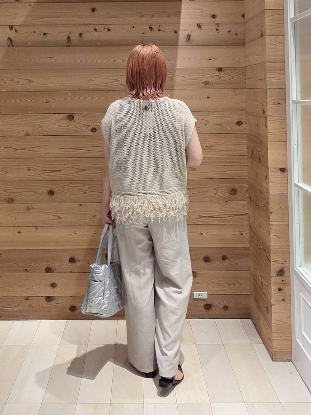 シルバー系のトートバッグ、ベージュ系のその他パンツ、ブラック系のタンクトップを着用したレディースの夏コーディネートの3枚目の写真