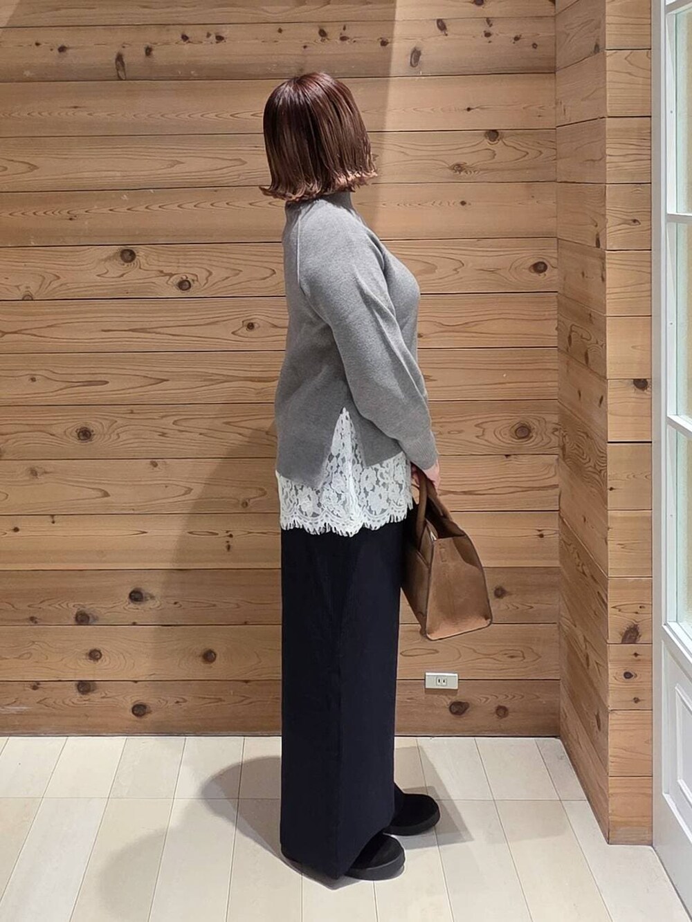 ベージュ系のダウンジャケット/コート、ベージュ系のショルダーバッグ、グレー系のニット/セーターを着用したレディースの冬コーディネートの2枚目の写真