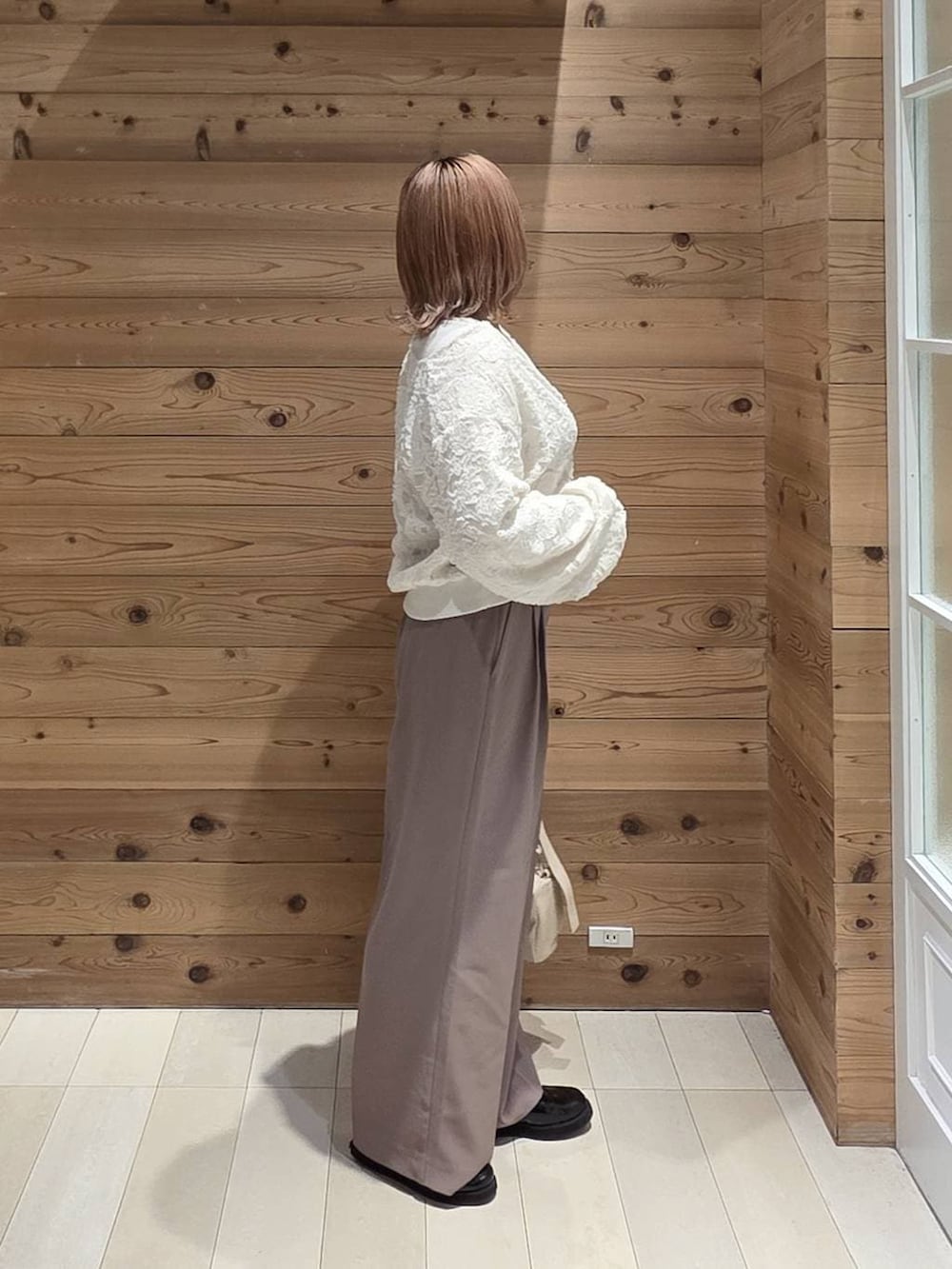 ホワイト系のブルゾン、ベージュ系のその他パンツ、ブラック系のローファーを着用したレディースの秋コーディネートの2枚目の写真