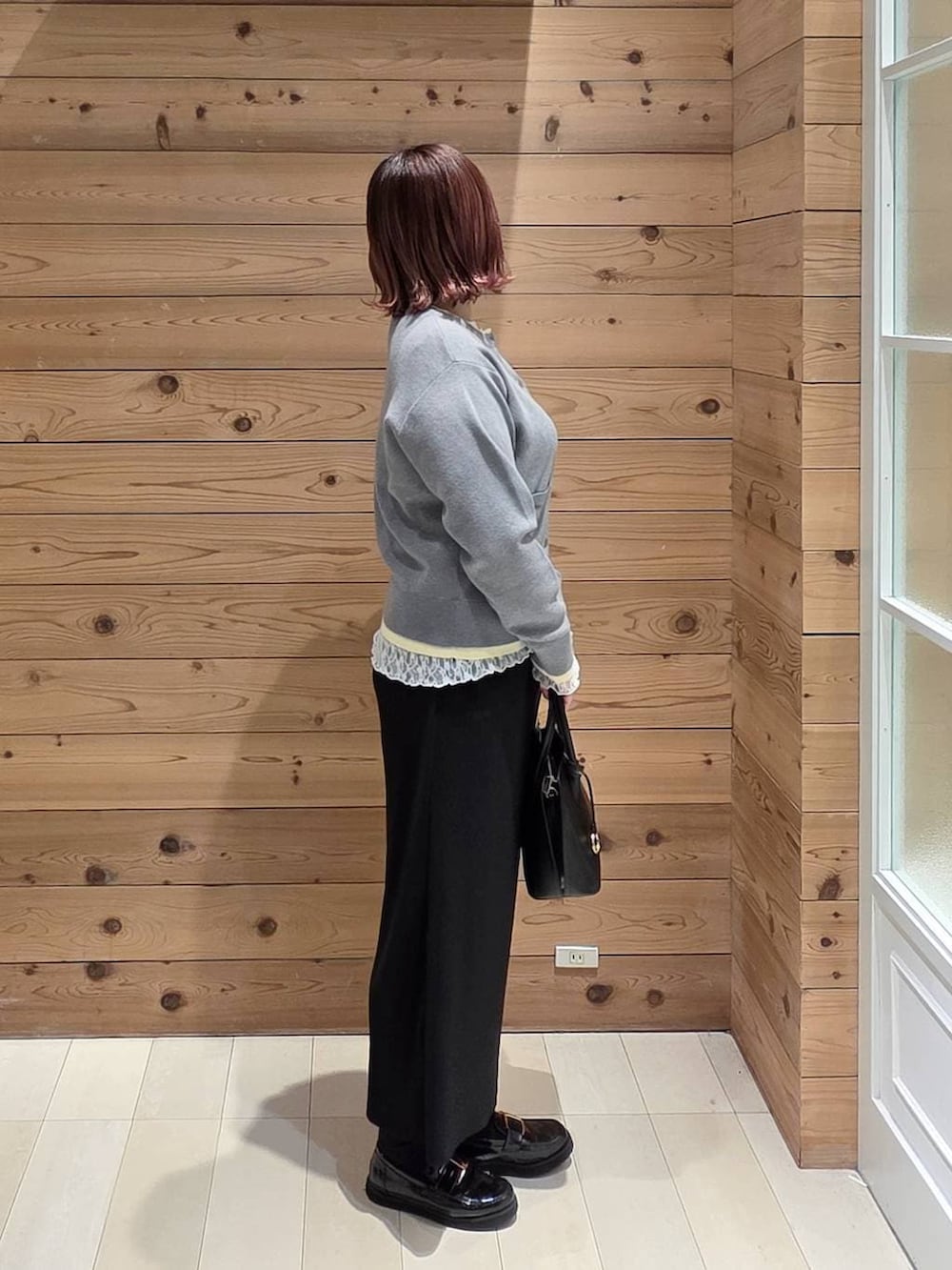 ブラック系のローファー、ブラック系のショルダーバッグ、ホワイト系のTシャツ/カットソーを着用したレディースの冬コーディネートの2枚目の写真