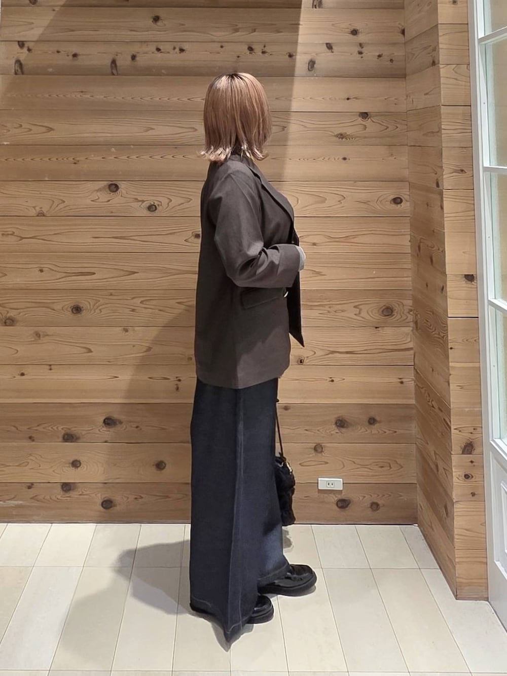 グレー系のTシャツ/カットソー、ブラック系のローファー、ブラック系のショルダーバッグを着用したレディースの秋コーディネートの2枚目の写真