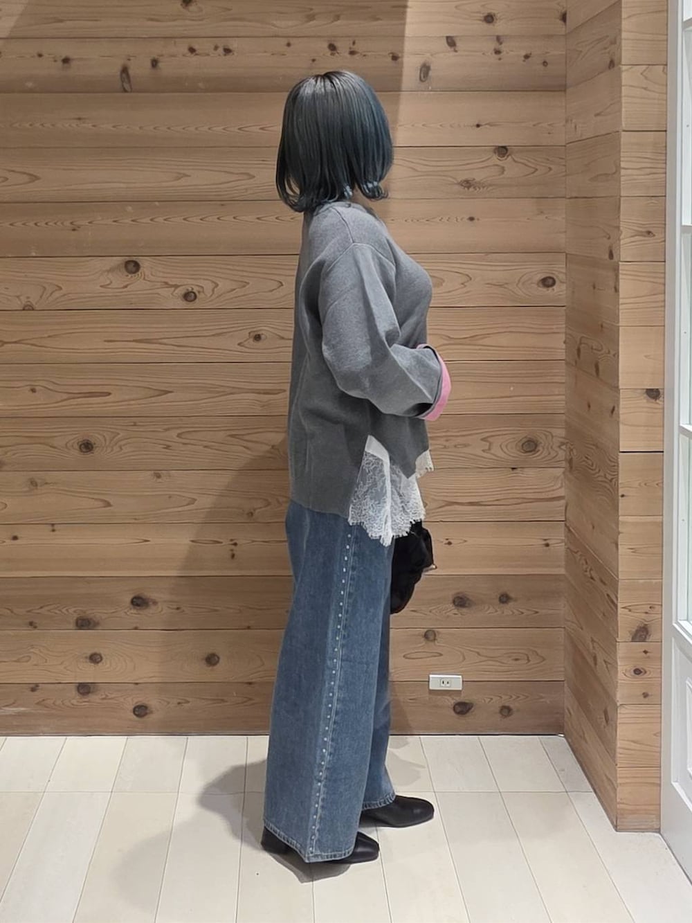 ブルー系のデニムパンツ、ホワイト系のTシャツ/カットソー、ブラック系のトートバッグを着用したレディースの秋コーディネートの2枚目の写真