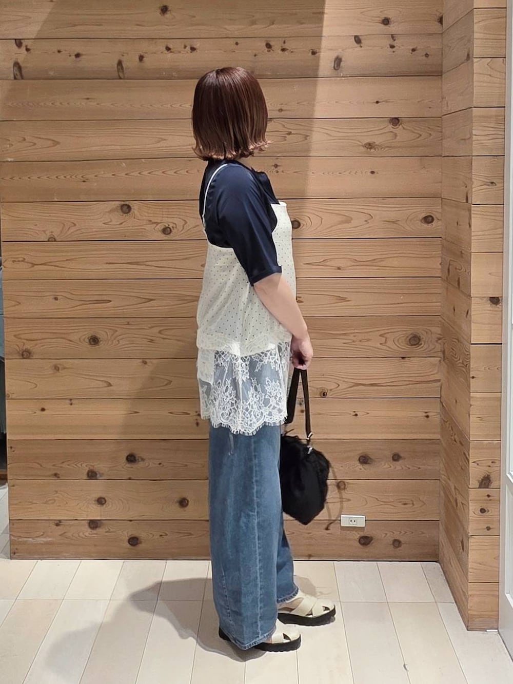 ブルー系のデニムパンツ、ブルー系のシャツ/ブラウス、ホワイト系のキャミソールを着用したレディースの春コーディネートの2枚目の写真