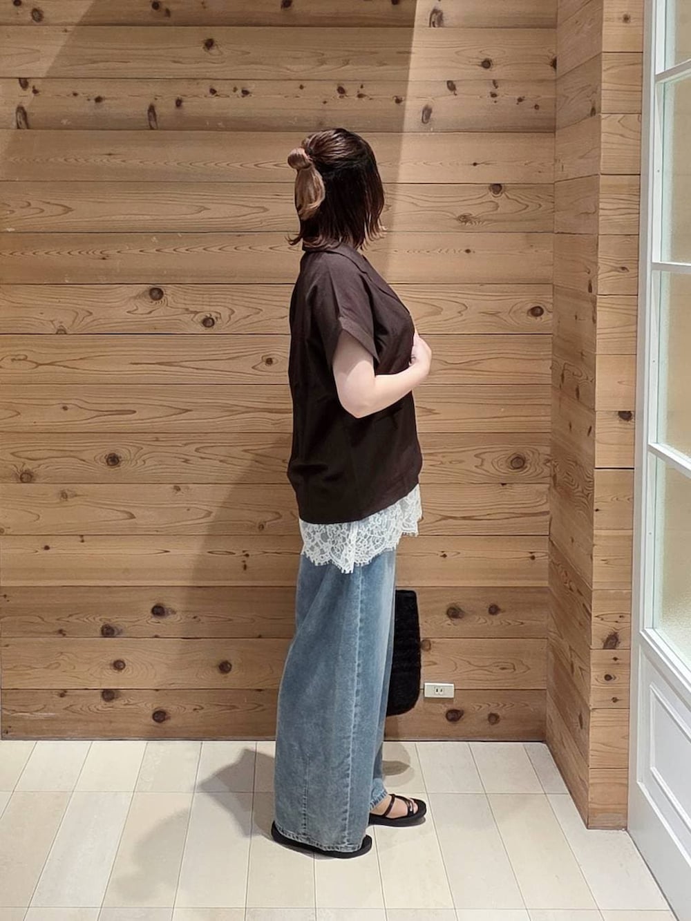 ブルー系のデニムパンツ、ホワイト系のタンクトップ、ホワイト系のキャミソールを着用したレディースの夏コーディネートの2枚目の写真