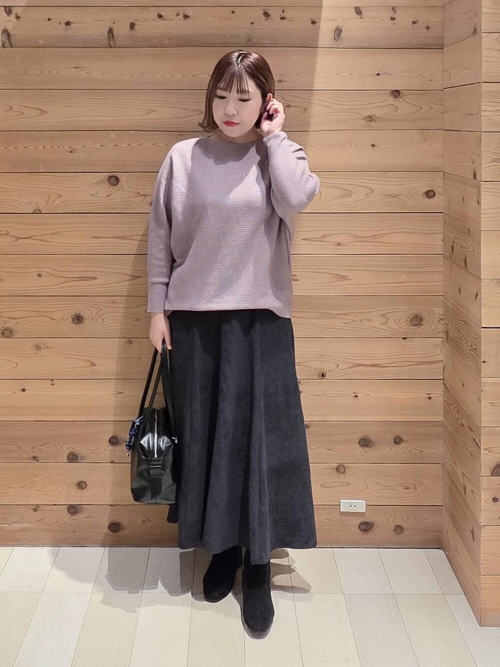 ブラック系のボストンバッグ、ブラウン系のブルゾン、グレー系のスカートを着用したレディースの冬コーディネートの4枚目の写真