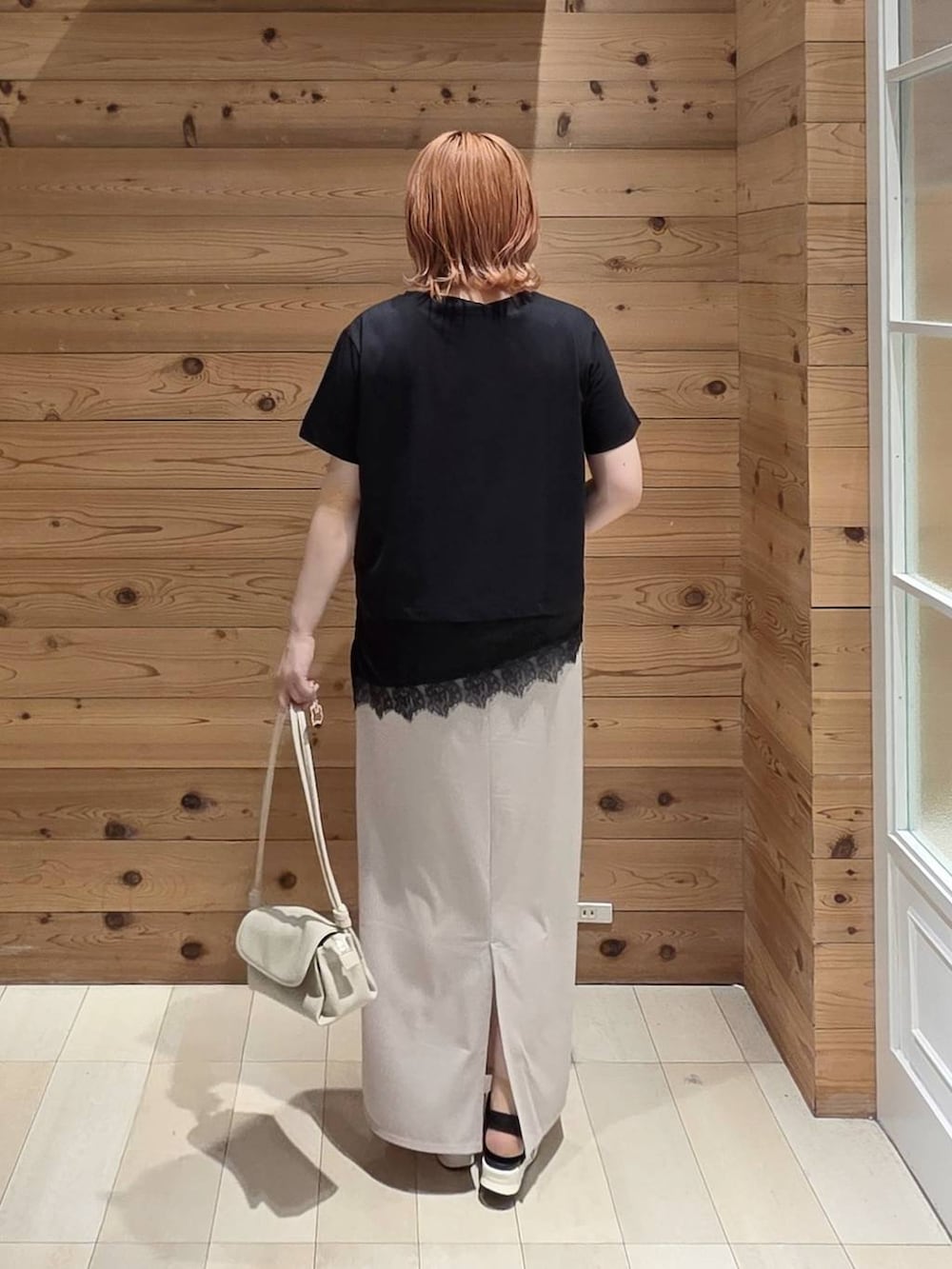 ホワイト系のスカート、ベージュ系のショルダーバッグ、ブラック系のサンダルを着用したレディースの夏コーディネートの3枚目の写真