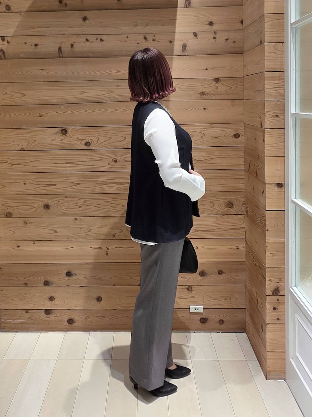 ブラック系のショルダーバッグ、ブラック系のパンプス、ブルー系のセットアップを着用したレディースの冬コーディネートの2枚目の写真