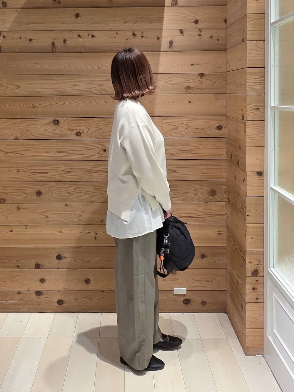 ブラック系のローファー、ブラック系のハンドバッグ、ブルー系のデニムジャケットを着用したレディースの春コーディネートの2枚目の写真