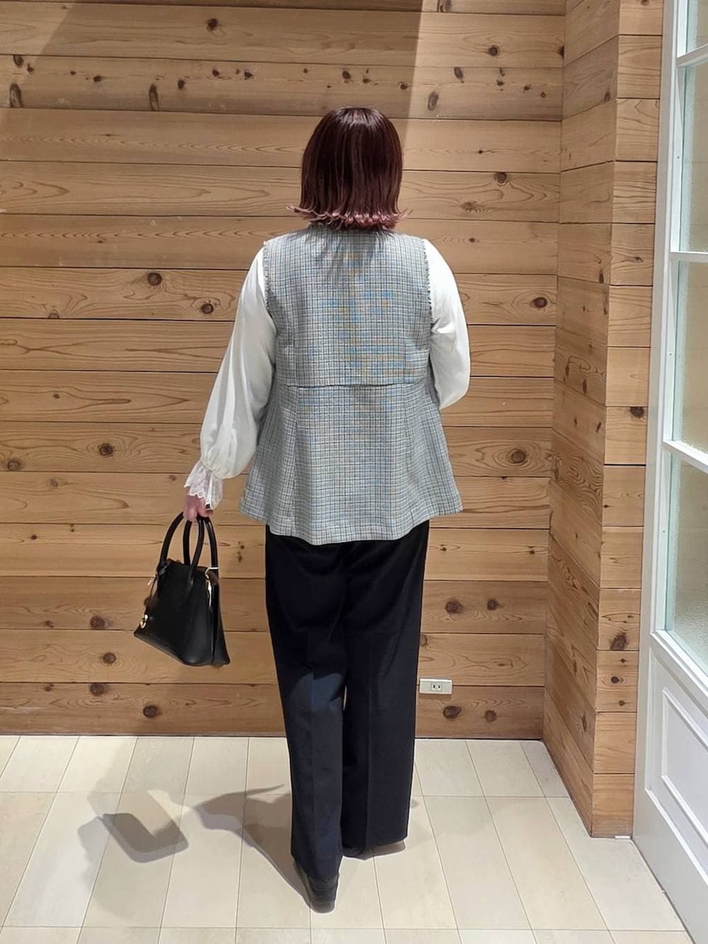 ブラック系のローファー、ブラック系のショルダーバッグ、ホワイト系のシャツ/ブラウスを着用したレディースの春コーディネートの3枚目の写真