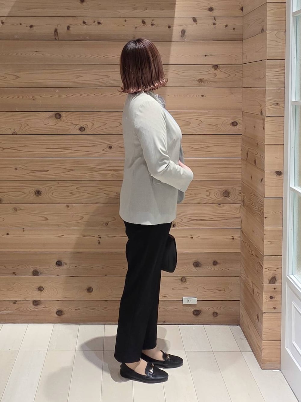 ブラック系のローファー、ブラック系のショルダーバッグ、ブラック系のセットアップを着用したレディースの冬コーディネートの2枚目の写真