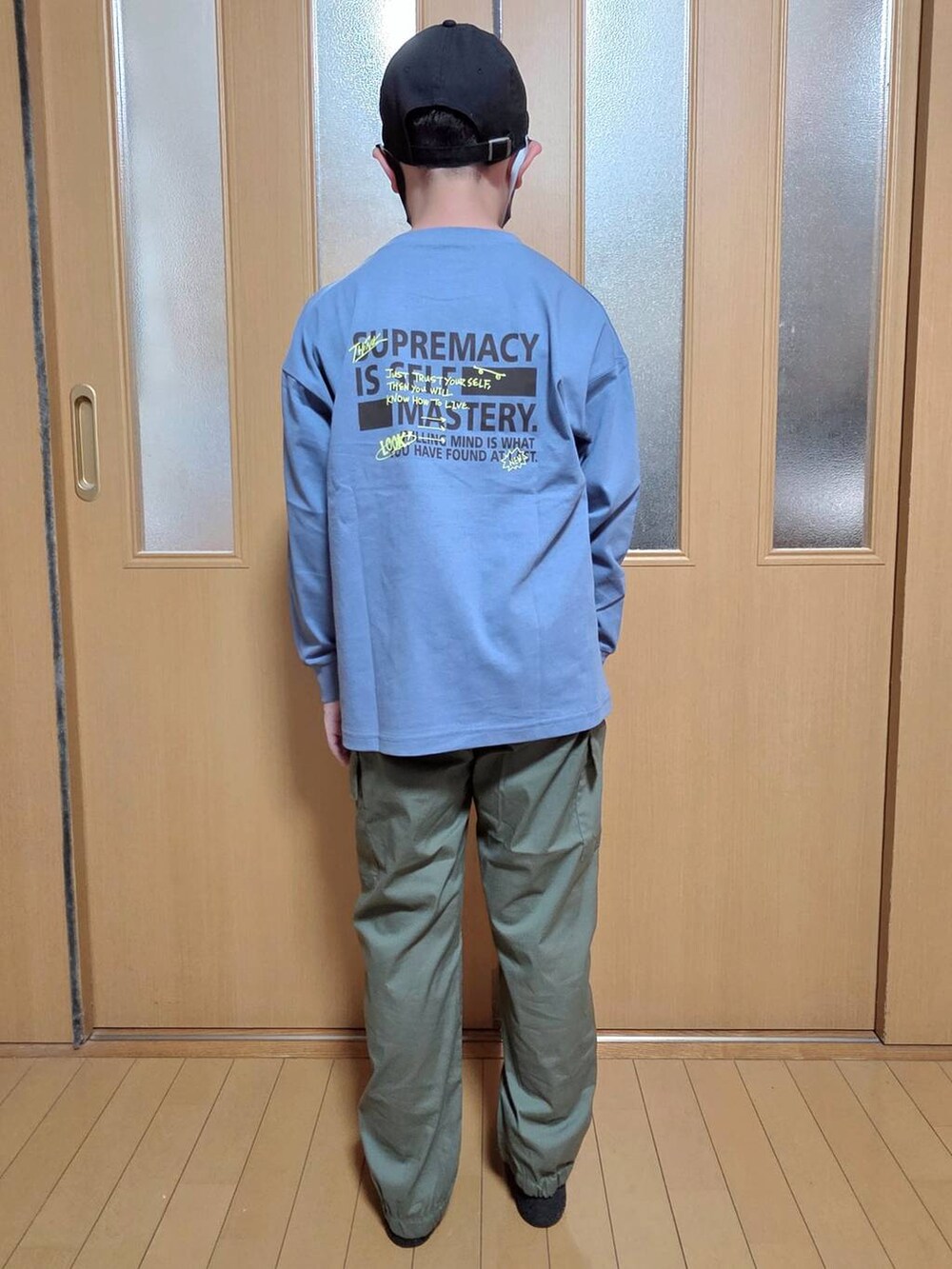 グリーン系のカーゴパンツ、ブルー系のTシャツ/カットソー、ブラック系のキャップを着用したキッズの秋コーディネートの3枚目の写真