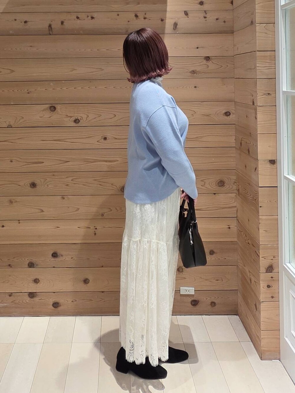 ブラック系のショルダーバッグ、ブルー系のダウンジャケット/コート、ホワイト系のTシャツ/カットソーを着用したレディースの冬コーディネートの3枚目の写真