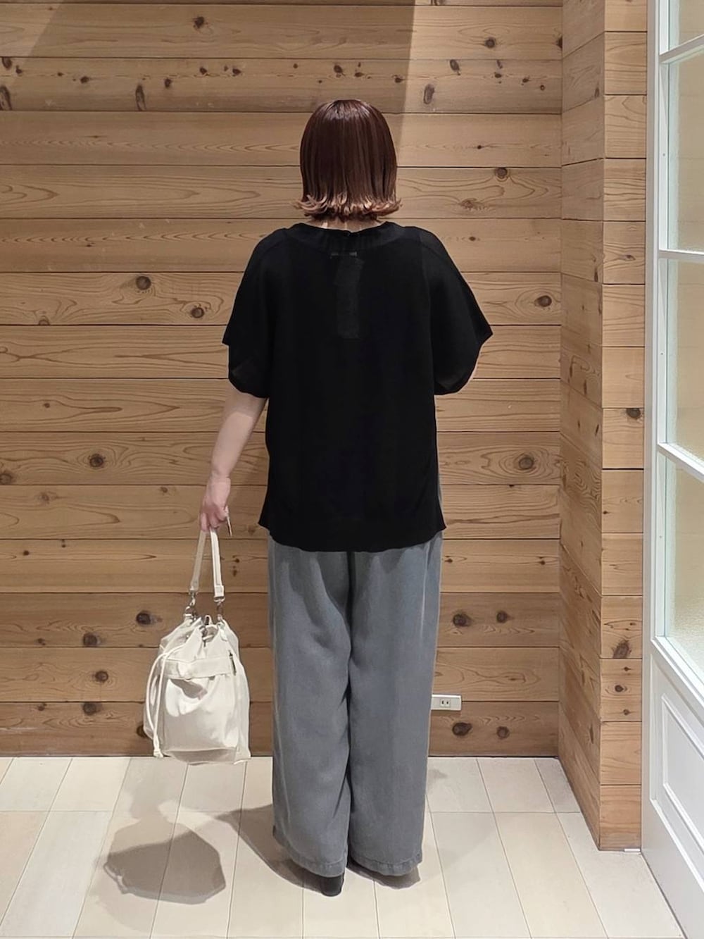 ホワイト系のショルダーバッグ、ブラック系のタンクトップ、ブラック系のデニムパンツを着用したレディースの春コーディネートの3枚目の写真