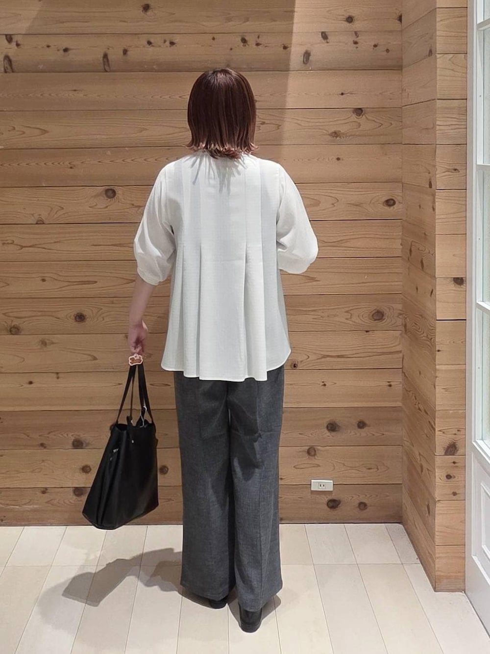 ブラック系のローファー、ブラック系のハンドバッグ、グレー系のその他パンツを着用したレディースの春コーディネートの3枚目の写真