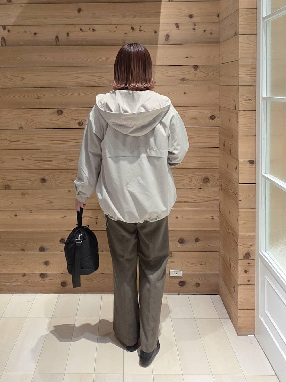 ブラック系のローファー、ブラック系のハンドバッグ、ベージュ系のマウンテンパーカーを着用したレディースの春コーディネートの3枚目の写真