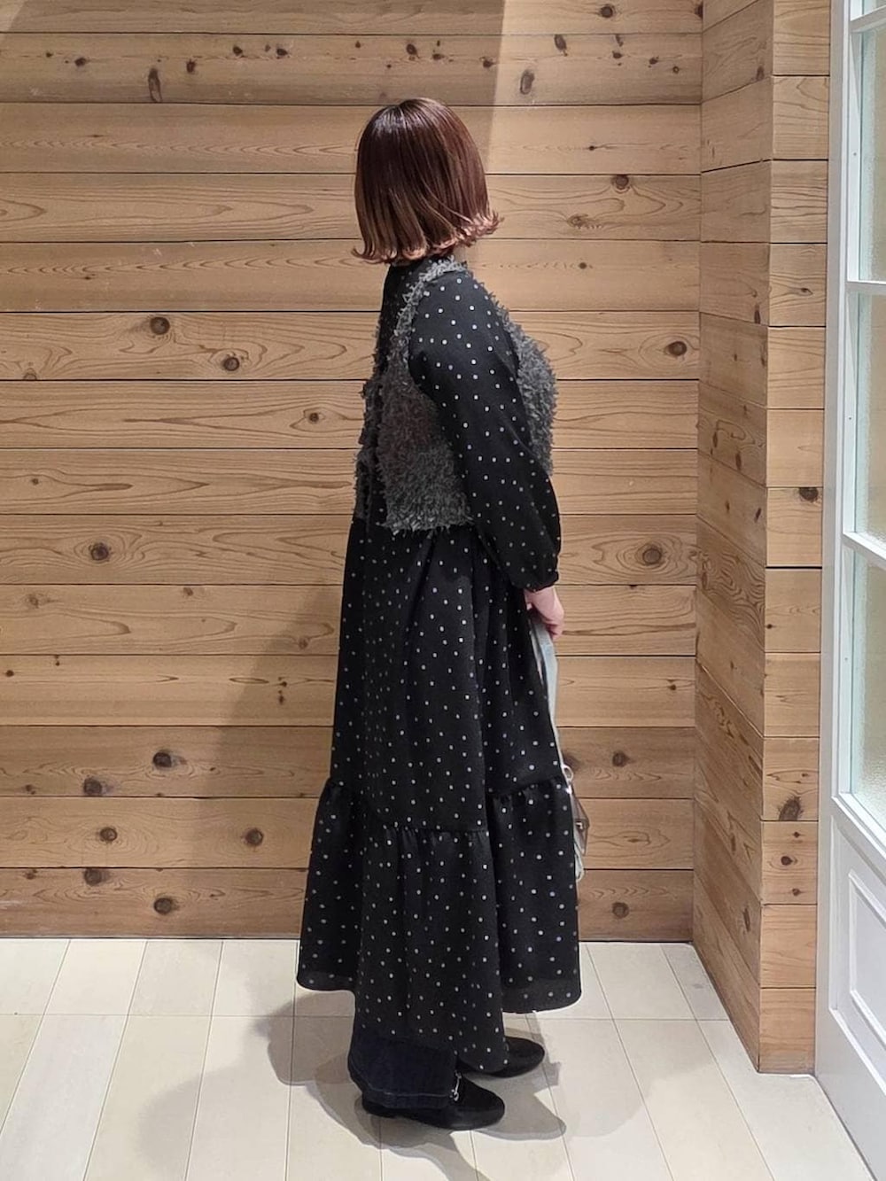 ブラック系のローファー、シルバー系のトートバッグ、ブルー系のデニムパンツを着用したレディースの冬コーディネートの2枚目の写真