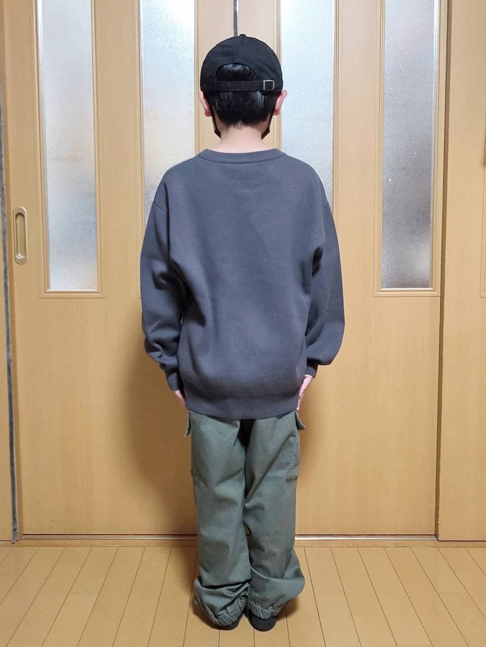 グリーン系のカーゴパンツ、グレー系のニット/セーターを着用したキッズの冬コーディネートの3枚目の写真