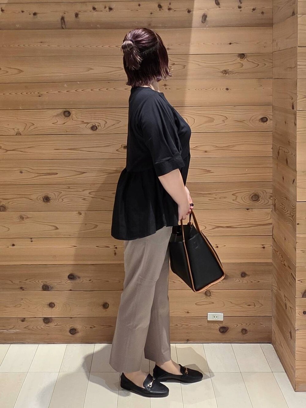 ブラック系のローファー、ブラウン系のその他パンツ、ブラック系のトートバッグを着用したレディースの秋コーディネートの2枚目の写真