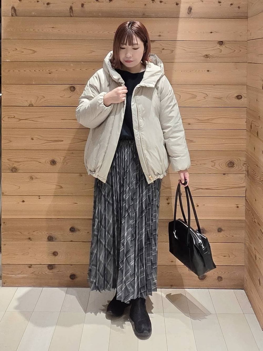 ベージュ系のダウンジャケット/コート、ブラック系のボストンバッグ、ブラック系のブーツを着用したレディースの冬コーディネートの4枚目の写真